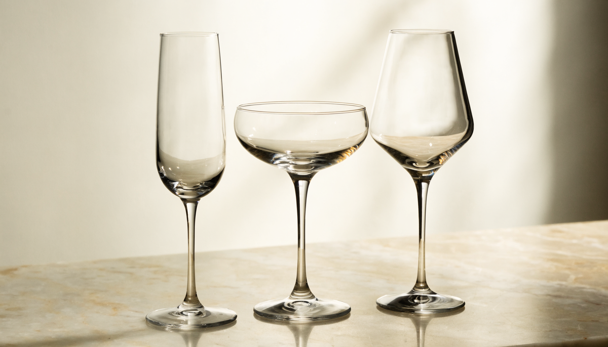Champagne flute, coupe en tulpglas naast elkaar op een marmeren ondergrond